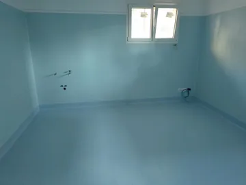 Stanza a una finestra, con pavimento e pareti in PVC azzurro